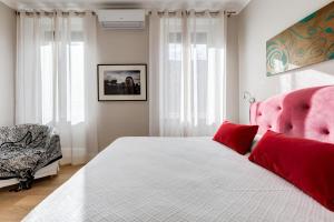 una camera da letto con un letto con cuscini rossi e una sedia di Vatican Guest House a Roma