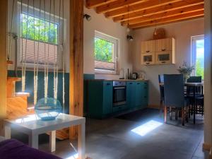 a kitchen with blue cabinets and a table in a room at Agroturystyka noclegi u Moniki domek drewniany in Oboźna Droga Masłów