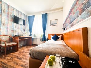 Un dormitorio con una cama y una mesa con fruta. en Hotel Condor, en Hamburgo