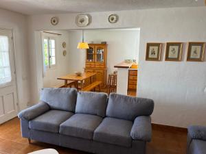 ein Wohnzimmer mit einem blauen Sofa und einem Tisch in der Unterkunft MISTRAL 10 by SOM Menorca in Fornells