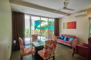 a living room with a couch and a table and chairs at Eternal wave by HappyInch in Calangute