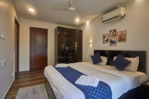 a bedroom with a large bed with blue and white pillows at Eternal wave by HappyInch in Calangute