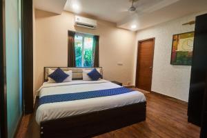 a bedroom with a large bed with blue pillows at Eternal wave by HappyInch in Calangute