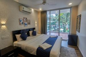 a bedroom with a large bed and a large window at Eternal wave by HappyInch in Calangute