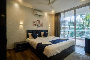a bedroom with a large bed and a large window at Eternal wave by HappyInch in Calangute
