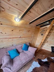 Habitación con sofá en una cabaña de madera en escapada romántica en Villa Serrana