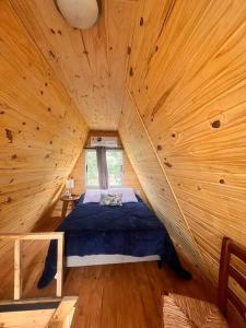 a bedroom in a log cabin with a bed in it at escapada romántica in Villa Serrana