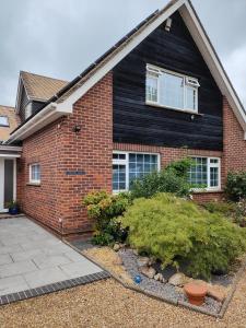 a brick house with a window and a yard at Bracken Lodge in Merston