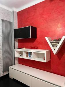a living room with a red wall with a tv at Casa Vale fronte mare in Ventimiglia