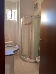 een badkamer met een douche, een wastafel en een toilet bij Casa Vale fronte mare in Ventimiglia