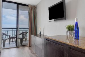 a living room with a television and a view of the ocean at Work With Breathtaking View, Direct Oceanfront Suite 413 in Myrtle Beach