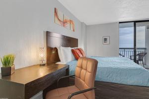 um quarto de hotel com uma cama, uma secretária, uma cama e uma varanda em Work With Breathtaking View, Direct Oceanfront Suite 413 em Myrtle Beach