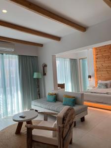 a living room with a couch and a bed at Notus Suites in Plakias