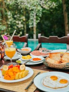 una mesa cubierta con platos de comida y bebida para el desayuno en Ceylon Olive Galle, en Galle