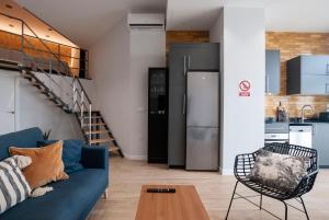 Precioso Loft en Valencia في فالنسيا: غرفة معيشة مع أريكة زرقاء ومطبخ