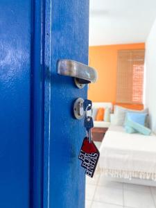 uma porta azul com uma chave num quarto em Apto Praia de Mariscal e Canto Grande Bombinhas SC - Canela Flats 02 em Bombinhas