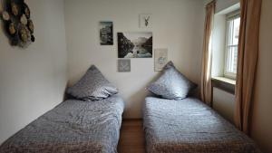 - 2 lits dans une petite chambre avec fenêtre dans l'établissement Weilheimer Ferienparadies, à Weilheim in Oberbayern