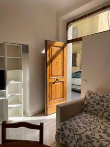 a room with a wooden door in a room with a chair at BellaFlo: Small apartment in the center of Florence in Florence