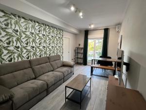 APARTMENT EL LLANO في لوسينا: غرفة معيشة مع أريكة وطاولة