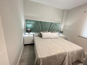 sypialnia z łóżkiem z zielonym zagłówkiem w obiekcie APARTMENT EL LLANO w mieście Lucena