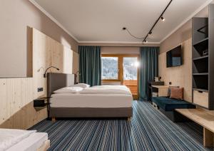 a hotel room with a bed and a desk at Hotel Ferienalm in Schladming