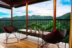 a porch with two chairs and a table on a balcony at Boulevard Resorts in Kakkadampoyil