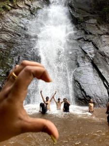 a group of people in the water in front of a waterfall at Heritage Homestay in Chikmagalūr