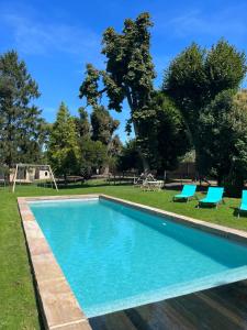 una piscina con sedie e un parco giochi di La Parenthèse Fléchoise, Chambre Armand a La Flèche