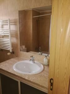 een badkamer met een wastafel en een spiegel bij Apartamento da Aldeia in Montijo