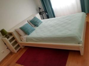 een bed in een kamer met een raam en een rood tapijt bij Apartamento da Aldeia in Montijo