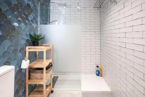 ein Badezimmer mit weißen U-Bahn-Fliesen und einem Regal mit einer Pflanze in der Unterkunft Precioso Loft en Valencia in Valencia