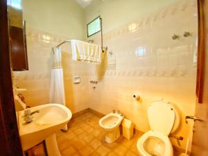 Łazienka z białą toaletą i umywalką w obiekcie CASA COSSIO w mieście Yerba Buena