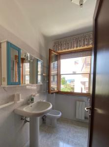 un bagno con lavandino, WC e finestra di La Tana Alghero ad Alghero