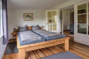 a large bed in a room with wooden floors at Ferienwohnung Bloeck in Busdorf