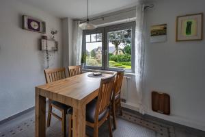 a dining room table with chairs and a window at Ferienwohnung Bloeck in Busdorf