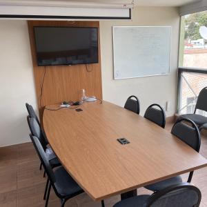 a conference room with a large wooden table and chairs at Hotel Cantareira in Niterói