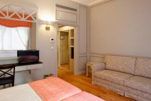 a living room with a couch and a table at Grande Hotel do Porto in Porto