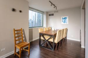 a dining room with a wooden table and chairs at 3b/3b SkyLoft with Navy Pier View Gym & Pool by ENVITAE in Chicago