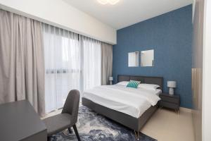 a bedroom with a bed and a blue wall at Elegant 2-BR Ritzy Retreat Steps from Burj Khalifa in Dubai