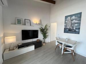 C-4 by SOM Menorca في سون بارك: غرفة معيشة فيها تلفزيون وطاولة وكراسي