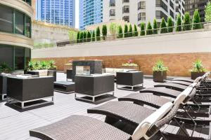 un patio avec des chaises et une cheminée dans un bâtiment dans l'établissement 3b/3b SkyLoft with Navy Pier View Gym & Pool by ENVITAE, à Chicago