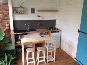 - une petite cuisine avec une table et deux tabourets dans l'établissement LE TIKI gîte côté canne, à Grand-Bourg