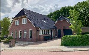 een rood bakstenen huis met een zwart dak bij Westenholte in Zwolle