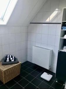 La salle de bains est pourvue de carrelage blanc, de toilettes et d'un lavabo. dans l'établissement Westenholte, à Zwolle