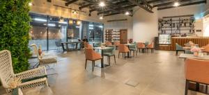 um restaurante com mesas, cadeiras e plantas em Pyramisa Hotel Apartments em Dubai