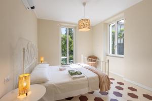 a white bedroom with a bed and a table at Villa Lilla Bellagio - Pool and Wine with Lake view in Bellagio