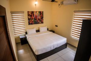 Zennova Furnished Apartment في أليبي: غرفة نوم بسرير ودهان على الحائط