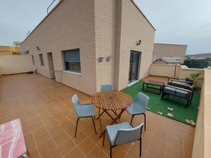 patio con mesa y sillas en el balcón en Amplio ático con terraza y aparcamiento entre el mar y desierto - Alborania, en Viator