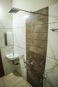 a bathroom with a sink and a shower with a mirror at Zennova Furnished Apartment in Alleppey