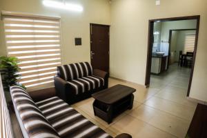 Zennova Furnished Apartment في أليبي: غرفة معيشة مع أريكة وطاولة